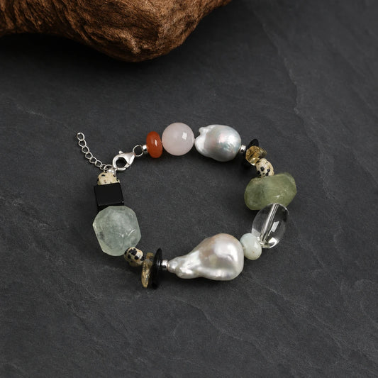 Close-up of multi-stone and large baroque pearl statement bracelet
