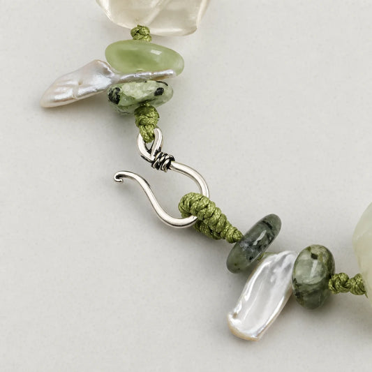 Close-up of prehnite and baroque pearl green stone bracelet