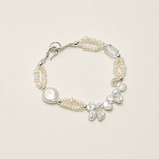 Baroque petal pearl and white quartz silver bracelet on dark stone background