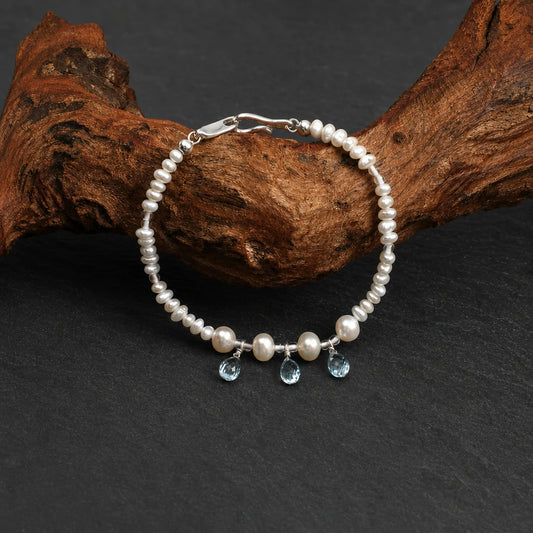 Close-up of flat pearl, egg pearl and blue topaz bracelet
